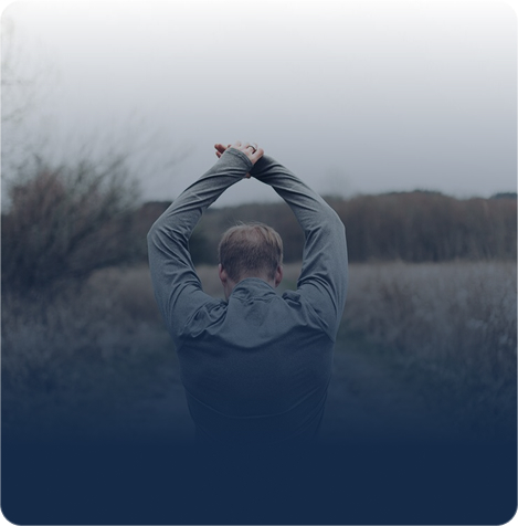 Man outdoors raising his arms above his head
